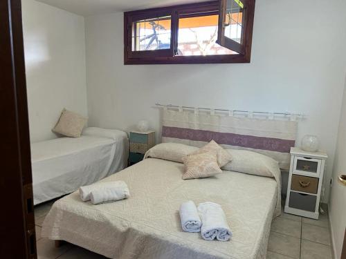Cette petite chambre comprend 2 lits et une fenêtre. dans l'établissement La conchiglia, à Masainas