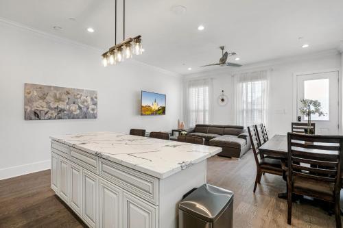 a kitchen and living room with a table and a couch at New 4 Bed luxury house w/Private Heated Pool in New Orleans