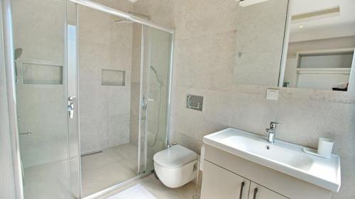a bathroom with a shower and a sink and a toilet at Villa Ersan 3 in Kas
