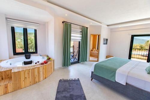 a bedroom with a tub and a bed and a television at Villa Ersan 3 in Kas