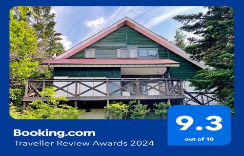 a green house with a sign that says travel review awards at HARUNA SKY Panoramic view of Nasu,private space surrounded by fir trees,relaxing stone bath,watching movies on a 120inch big screen in Nasu