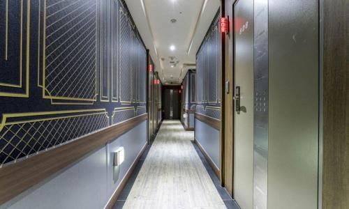 a hallway of a building with blue walls and a long corridor at Dongtan BobosHotel in Hwaseong