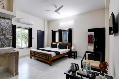 a bedroom with a bed and a television in it at Hotel O SS INN Hotels & Homes in Bhubaneshwar