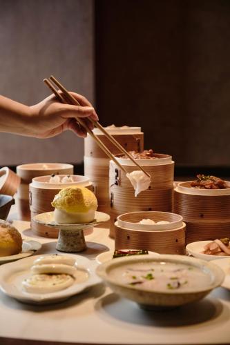 una persona che tiene le bacchette su un tavolo di cibo di SHANAN·深溪 ad Anji