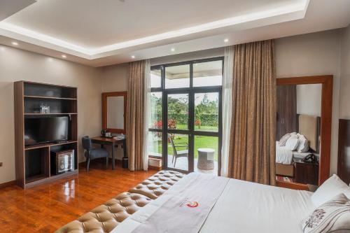 a bedroom with a large bed and a large window at Sarova Maiyan Nanyuki in Nanyuki