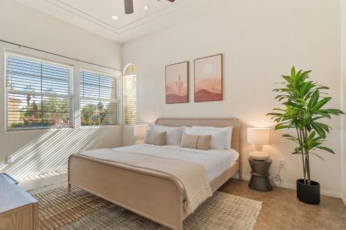 een slaapkamer met een bed en een potplant bij Desert Paradise by VARE - Puerta Azul - Pool & Spa in La Quinta