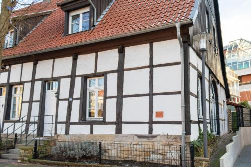 a white and black house with a red roof at Denkmalgeschütztes Fachwerkhaus im Zentrum mit Garage in Ibbenbüren
