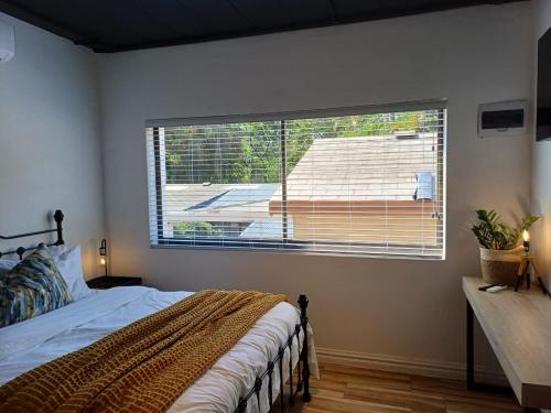 a bedroom with a bed and a large window at Buckingham Studio in Pinetown