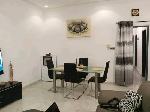 - un salon avec une table et des chaises dans l'établissement Entrée personnelle fidjrossè, à Cotonou