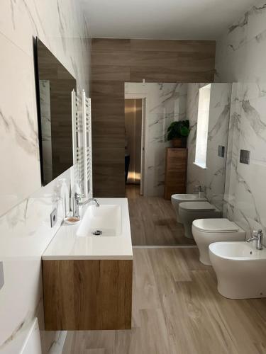 La salle de bains est pourvue de 3 lavabos et de 2 toilettes. dans l'établissement B&B La Terrazza, à Cotronei