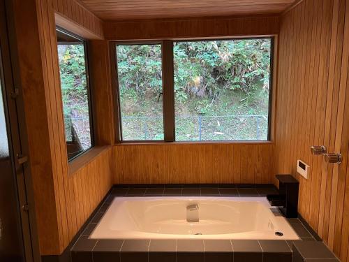 eine große Badewanne in einem Zimmer mit Fenster in der Unterkunft Mizuho Highland - Camp - Vacation STAY 42325v 