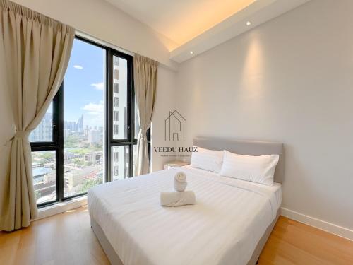 um quarto com uma cama branca e uma grande janela em Sentral Suites at Kuala Lumpur Sentral by Veedu Hauz em Kuala Lumpur