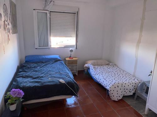 een slaapkamer met 2 bedden en een raam bij Habitación luminosa en piso compartido in Mairena del Aljarafe