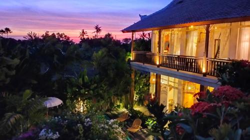 a view of a house with a garden at dusk at Amar Boutique Hotel in Canggu