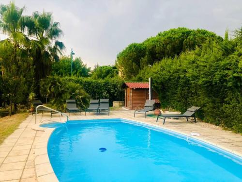 einen blauen Pool mit Stühlen und einem Pavillon in der Unterkunft Villa 3* piscine vue montagne proche mer & Espagne in Le Boulou
