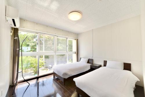 2 camas en una habitación con ventana en Guest House Karst, en Ufudo