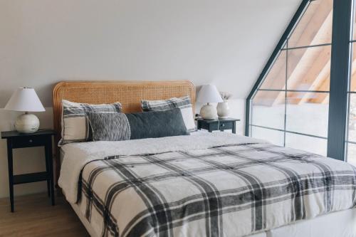 una camera con un letto e due tavoli con lampade di Hilltop Cabin a Munteni