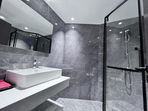 een badkamer met een wastafel en een douche bij Mei Gang Hotel in Guangzhou