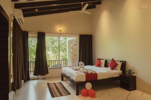 a bedroom with a bed and a large window at THE INFINITY PENCH RESORT in Khawāsa