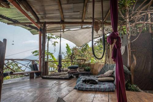 un gatto che dorme su un letto su un portico di Earthship amazing Cabins with lake view a San Marcos La Laguna