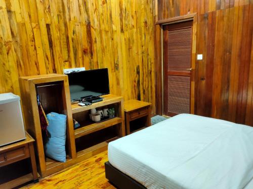um quarto com uma cama e uma televisão num quarto em KEMBARA RESORT em Setiu