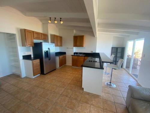 a kitchen with a refrigerator and a counter top at Tranquil Beachfront Duplex-type Private House! in Hauula
