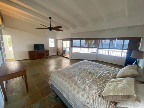 a bedroom with a bed and a ceiling fan at Tranquil Beachfront Duplex-type Private House! in Hauula