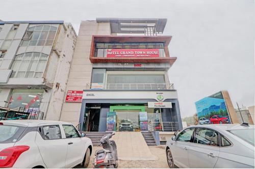 a building with cars parked in front of it at Grand Townhouse in Palwal