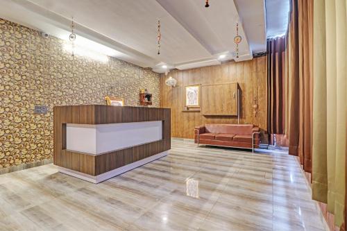 a waiting room with a reception desk and a couch at Grand Townhouse in Palwal