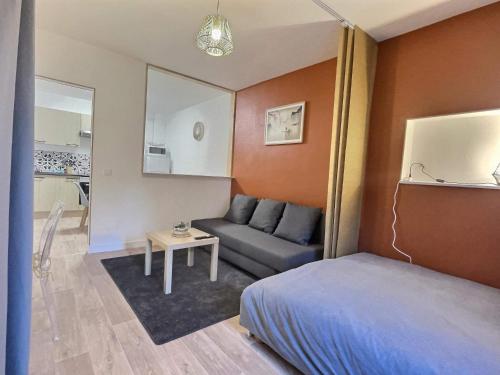 Habitación pequeña con cama y sofá en Petit cocon, en Saint-Avold