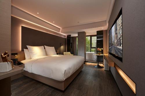 a bedroom with a large bed and a flat screen tv at Intercity Yangzhou Slender West Lake in Yangzhou