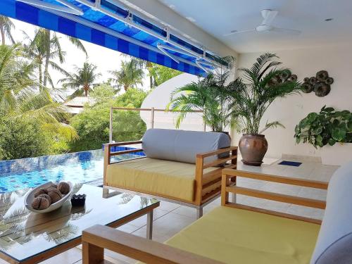 een woonkamer met een bank en een tafel bij Beachside 3-Bedroom Townhouse w Private Pool at 70 Meters from Beach in Ban Bang Po