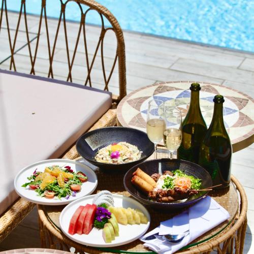 a table with plates of food and bottles of wine at Icon Saigon - LifeStyle Design Hotel in Ho Chi Minh City