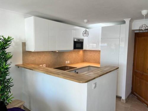 une cuisine avec des armoires blanches et un comptoir dans l'établissement La Mer Résidence La Fontaine, à La Seyne-sur-Mer