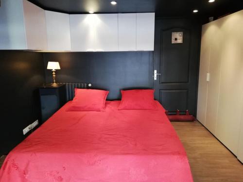 - un lit rouge avec des oreillers rouges dans l'établissement villa avec piscine ,plages à 7 min(5km), à Frontignan