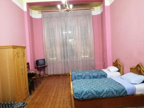 Un dormitorio con 2 camas y una ventana con paredes rosas. en Berlin Hotel, en El Cairo