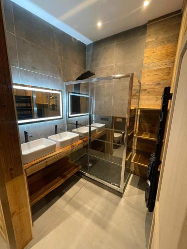 une salle de bain avec deux lavabos et une douche en verre dans l'établissement Maison à Moutiers 3 Vallées 4 Chambres 10 pers, à Moutiers