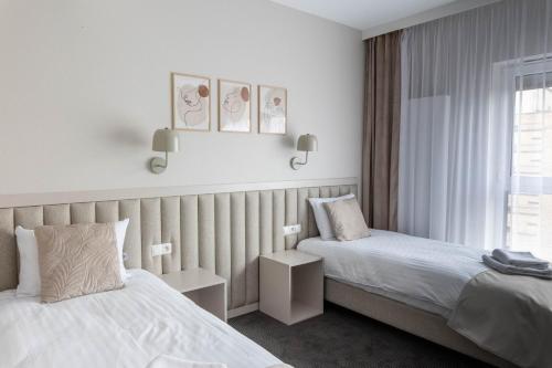 a hotel room with two beds and a window at Apartamenty Wolności 6 self check-in 24h in Poznań