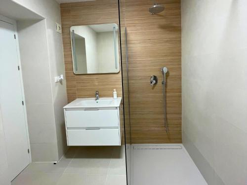 a bathroom with a sink and a shower with a mirror at Modern private Suite at fantastic villa near Fuengirola in Mijas