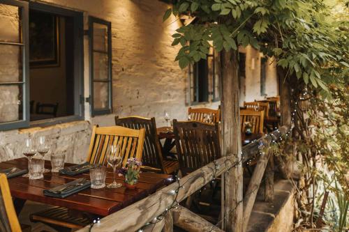 um restaurante com uma mesa e cadeiras de madeira e uma árvore em Skillogalee Estate em Clare