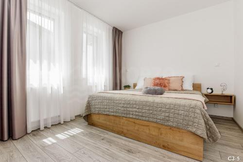 a bedroom with a bed and a large window at KORZO LIPNO C in Lipno nad Vltavou