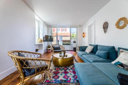 un salon avec un canapé bleu et une table dans l'établissement ALOE KEYWEEK Architect Apartment with terrace and garage Biarritz, à Biarritz