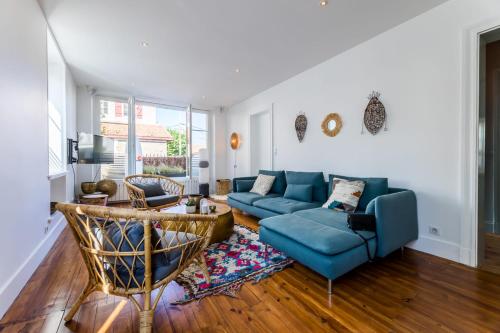 un salon avec un canapé bleu et une table dans l'établissement ALOE KEYWEEK Architect Apartment with terrace and garage Biarritz, à Biarritz