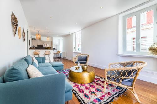 un salon avec un canapé bleu et des chaises dans l'établissement ALOE KEYWEEK Architect Apartment with terrace and garage Biarritz, à Biarritz