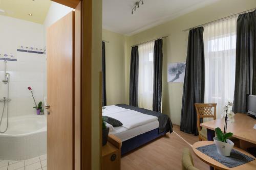 ein Schlafzimmer mit einem Bett und ein Badezimmer mit einer Badewanne in der Unterkunft Hotel Scaletta in Pula