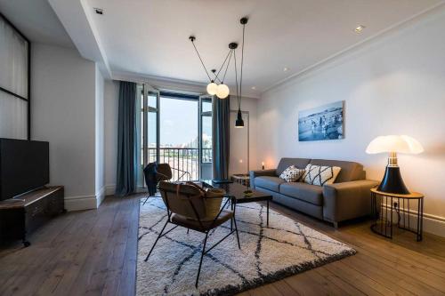 un salon avec un canapé et une table dans l'établissement BEACHVIEW KEYWEEK Beachfront Renovated Apartment with Parking in Biarritz, à Biarritz