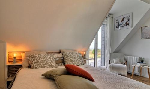 a bedroom with a bed with pillows on it at LA CORENTINE in Plouarzel