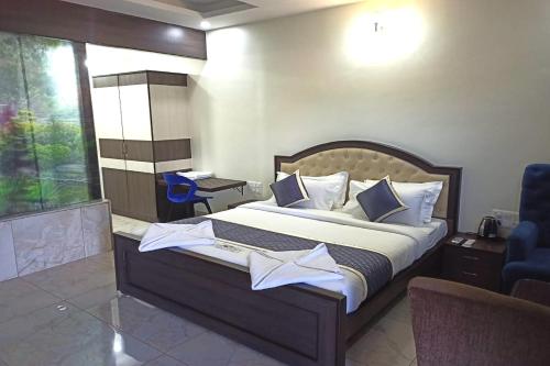 - une chambre avec un grand lit et une chaise bleue dans l'établissement DMM Resort, à Urdigere