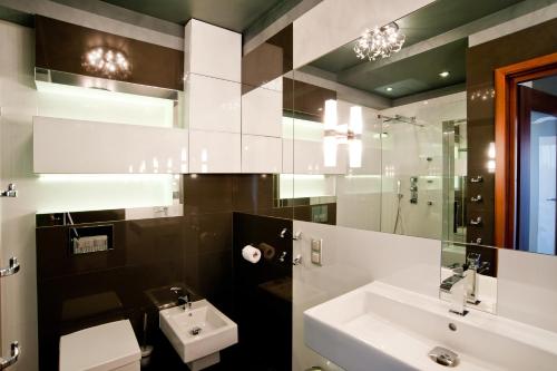 W łazience znajduje się umywalka, toaleta i lustro. w obiekcie Młoda Europa w Łodzi