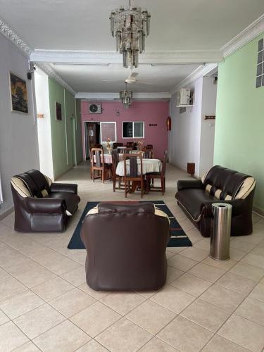 a living room with leather furniture and a dining room at HOTEL AKBAR in Mahajanga